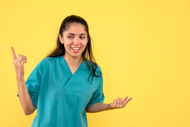 听诊器正面图快乐美丽的女医生在黄色背景上张开双手微笑专业自信
