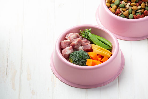 肉健康新鲜的宠物食品配料在白色木质表面胡萝卜干堆