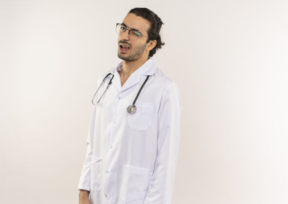 长袍年轻的男医生戴着眼镜 穿着白袍 带着听诊器医生年轻眨眼
