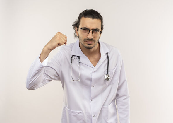长袍自信的年轻男医生戴着眼镜穿着白袍用听诊器做着有力的手势男人男性穿着