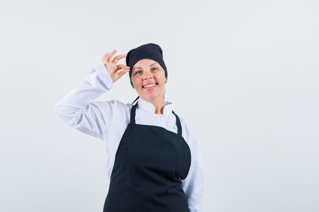 美女身着制服的女厨师 围裙显示出良好的姿态和愉快的表情 前视图卷发欢呼年轻