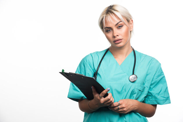 站着女医生用听诊器把剪贴板放在白色的表面上制服女性人类