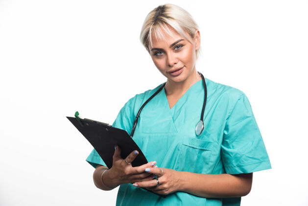 站着女医生用听诊器把剪贴板放在白色的表面上文件女性医生