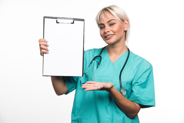 文件夹微笑的女医生拿着一个剪贴板指着白色的表面手文件制服女士