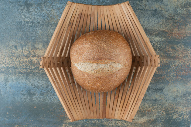 产品一个新鲜的棕色面包包放在木篮子里营养食品烹饪