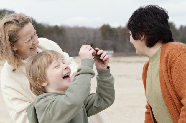 娱乐中枪快乐小子抱着植物祖母户外海滩