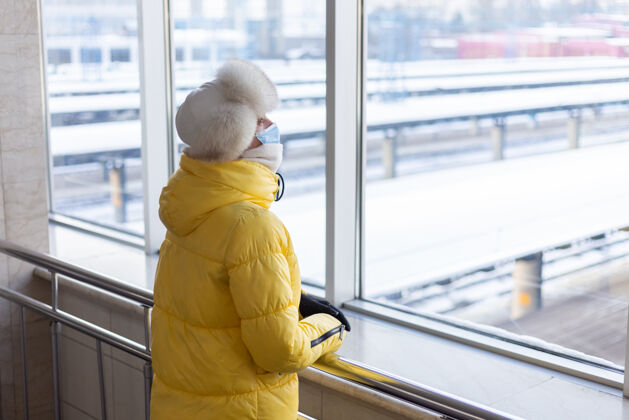 城市年轻女子在火车站戴着防护面具 脸上穿着冬装的乘客医疗Quarantine妇女