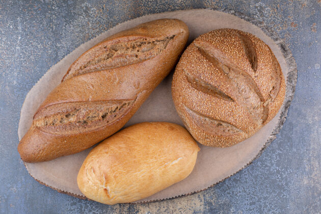 酵母在大理石表面的木板上放各种面包面包皮面粉面包