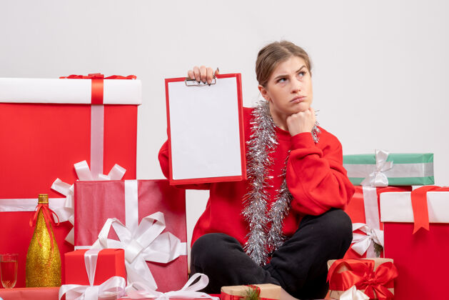 坐着漂亮的女人围坐在圣诞礼物旁边 白色的纸条便条礼物人