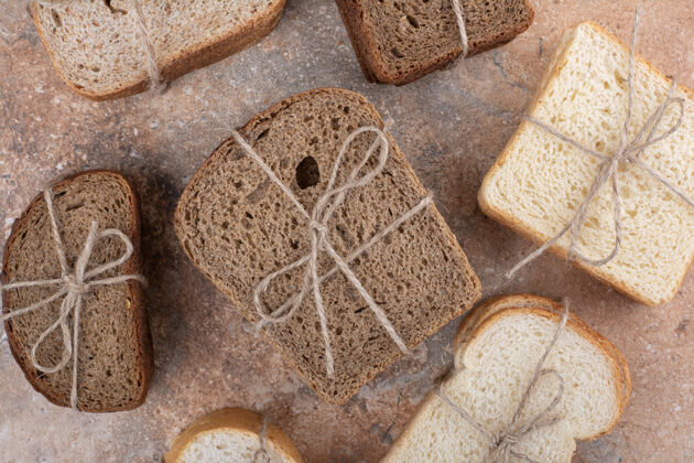 法式面包各种各样的面包用绳子绑在大理石背景上美味新鲜小麦