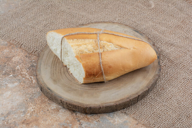 松脆的用绳子绑在木板上的新鲜面包面包好吃的粗麻布