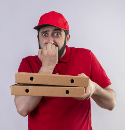 拿着焦急的年轻英俊的白人送货员穿着红色制服 戴着帽子 手里拿着披萨盒 把手放在嘴上 隔着白色制服嘴男人