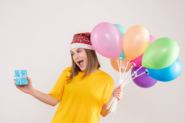 年轻女性手持小礼物和白色气球的年轻女性礼物生日欢乐
