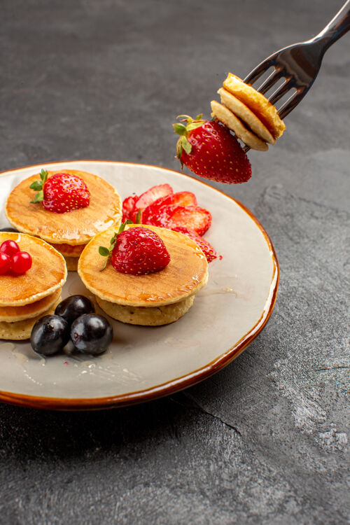 餐前视图小美味的薄饼与水果在灰色的表面馅饼蛋糕水果草莓前面浆果