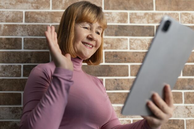 家庭中枪笑脸女子手持平板电脑笑脸熟悉视频通话