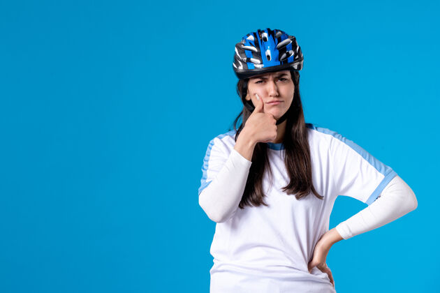 自行车前视图穿着运动服的年轻女性 蓝色墙上戴着头盔成人专业年轻女性
