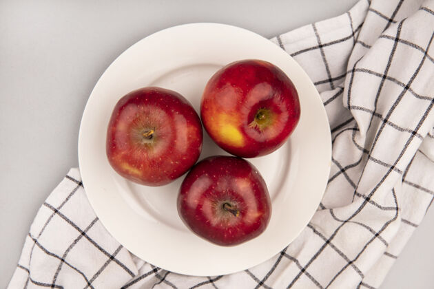 水果白色墙壁上格子布盘子上甜红苹果的俯视图农业视图顶部