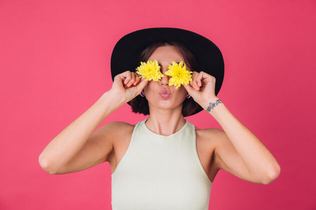 菊花时尚女人戴着帽子 送上飞吻用黄色紫苑遮住双眼 春意盎然 快乐情感与世隔绝的空间祝贺植物学精品