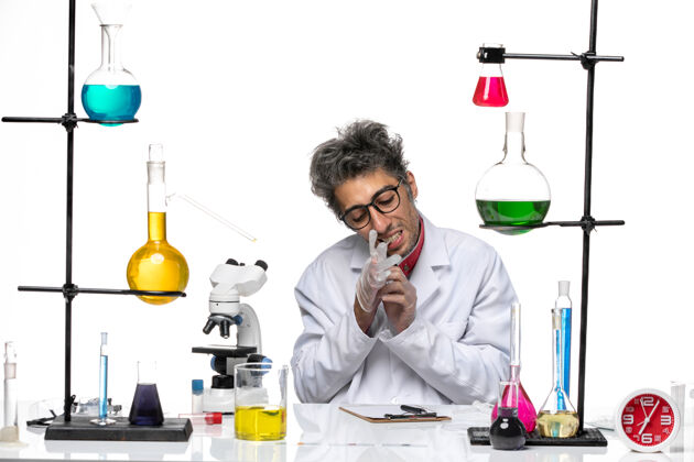 化学正面图穿着白色医疗服的中年化学家拿着溶液坐着视图医学烧杯