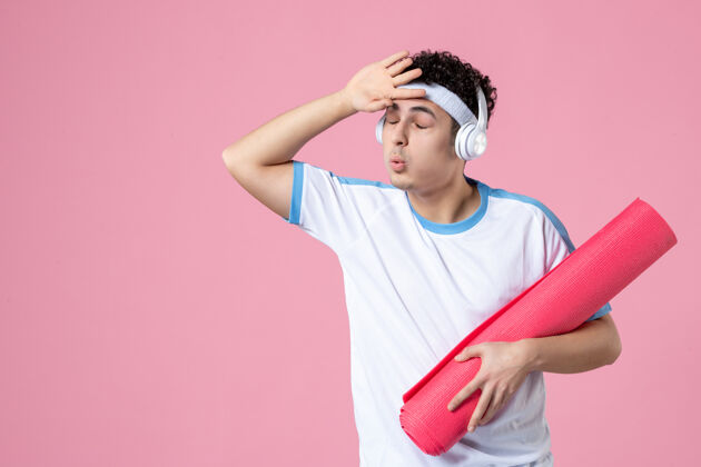 运动正面图穿着运动服的年轻男性 粉色墙上有瑜伽垫成人前面水平