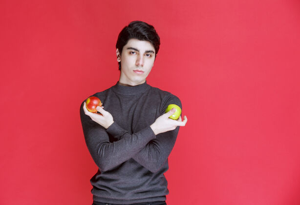 年轻手里拿着青橘子和红苹果的人男性成人有机