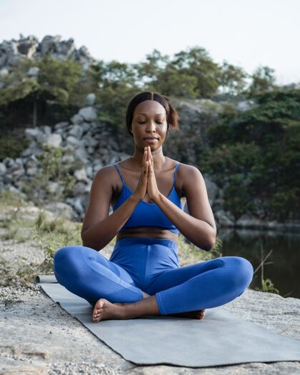 平静非裔美国瑜伽老师在户外练习身体平衡老师女人