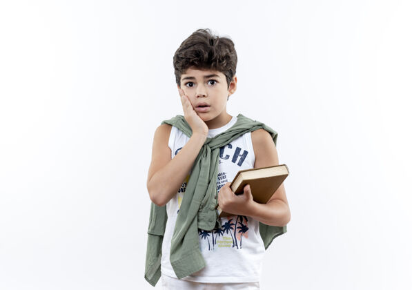 握着害怕的小男生拿着书 把手放在脸上孤立的白色表情脸颊手势