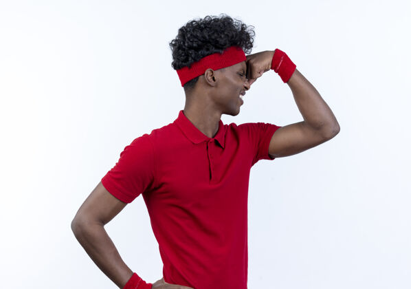 强壮站在侧视图紧张的年轻美国黑人运动男子戴着头带和腕带做着强烈的手势白色姿势头带站立