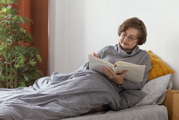 治疗中枪女人在床上看书室内放松保健