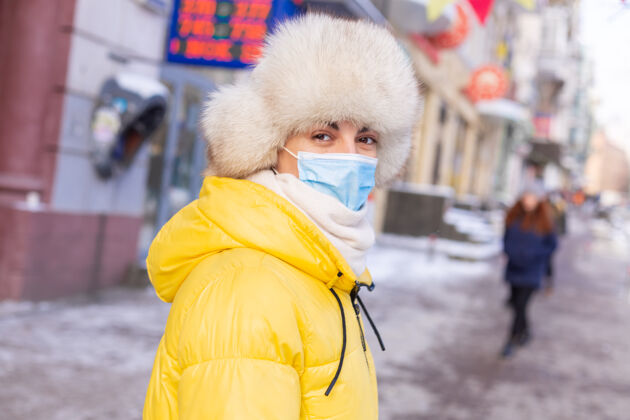 脸在寒冷的日子里 一个穿着冬衣的女人在公共汽车站等公共汽车乘客城镇坐着