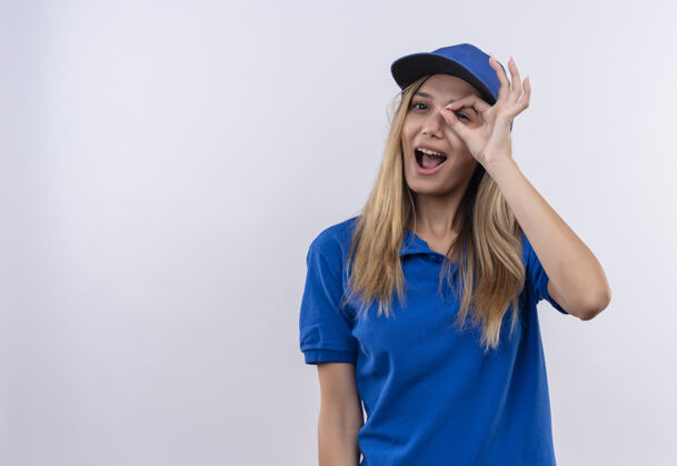 制服快乐的年轻送货女孩穿着蓝色制服 戴着帽子 在白色的墙壁上显示出孤立的表情和复制空间送货手势穿着