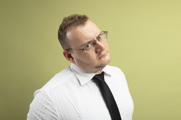 眼镜未出租的成年斯拉夫男子戴着眼镜 打着领带 看着相机隔离在橄榄绿的背景与复制空间斯拉夫领带复制