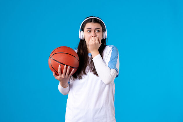 运动装前视图吓坏了戴着耳机拿着篮球的年轻女性球成人篮球
