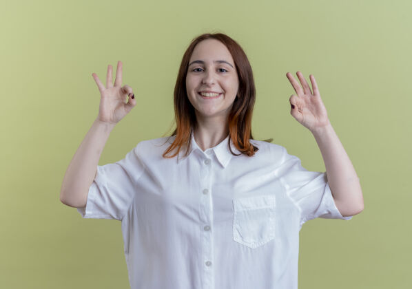 女孩微笑着的年轻红发女孩在橄榄绿上表现出良好的姿态表情橄榄绿色