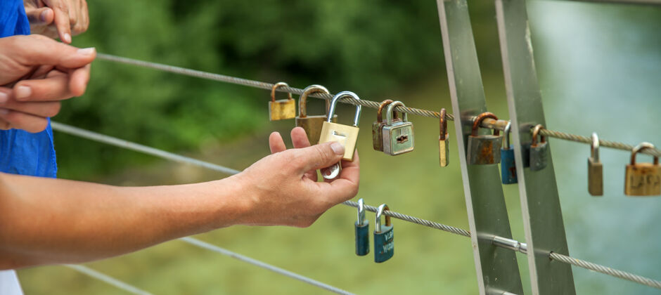 在一起手在绳子上挂锁的特写镜头-爱的概念关闭情侣锁