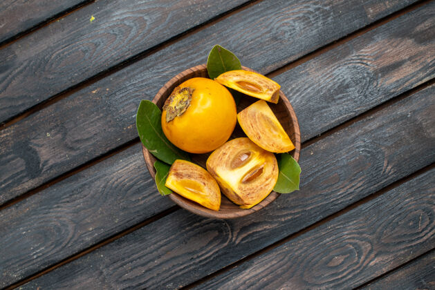 乡村顶视图新鲜甜甜的柿子放在木质质朴的餐桌上 醇香果香健康顶部黄色木头