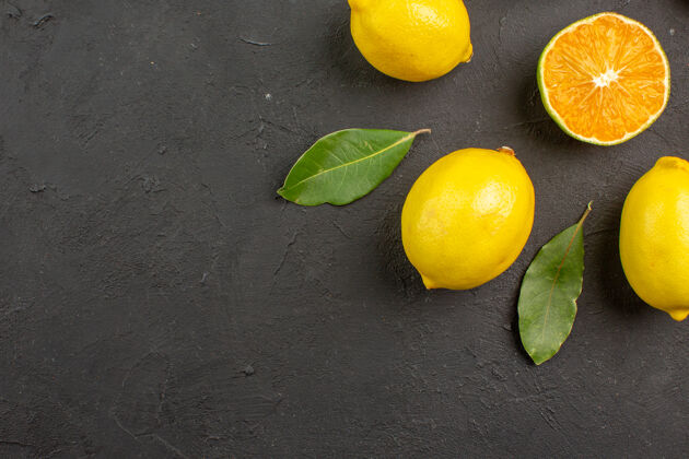 深色顶视图新鲜的酸柠檬衬在深色的桌子上柑橘黄色的水果复制空间顶部顶视图