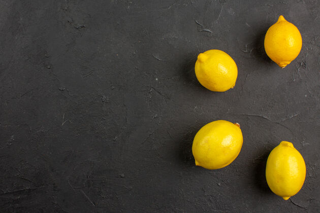 顶部顶视图新鲜柠檬排在黑暗的桌子柑橘黄色的水果免费空间的文字黄色食物新鲜柠檬色