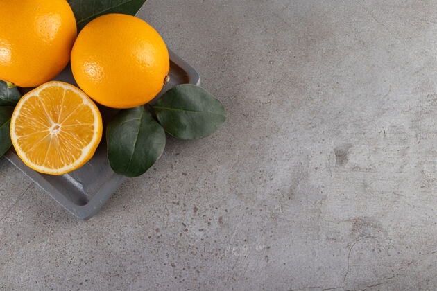 顶视图石头桌上放着新鲜多汁橙子的深色木板美味有机明亮