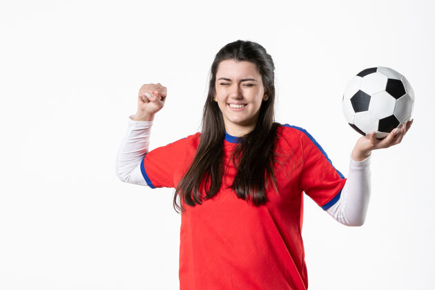 肖像正面图快乐的年轻女子穿着运动服 拿着足球青年人人