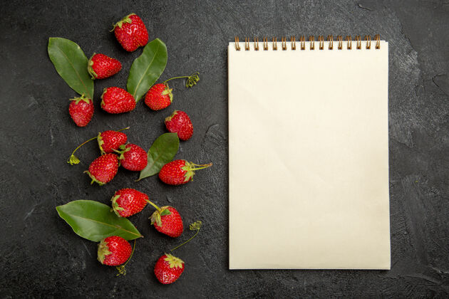 健康顶视图新鲜的红色草莓放在深色的餐桌上 水果浆果成熟的颜色颜色多汁记事本