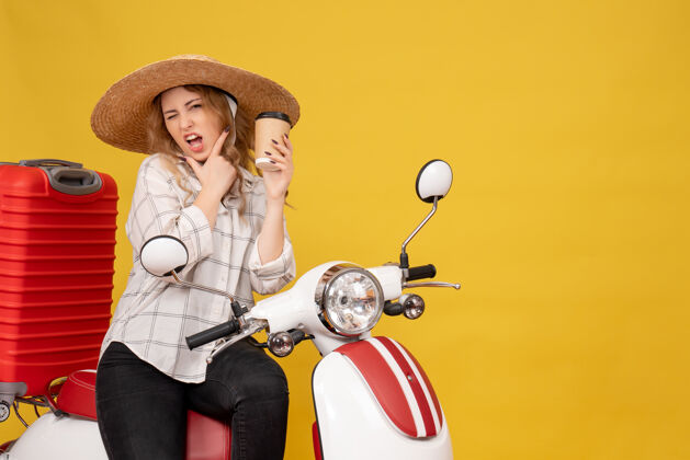 人顶视图雄心勃勃的年轻女子戴着帽子 坐在摩托车上 拿着咖啡帽子咖啡比赛