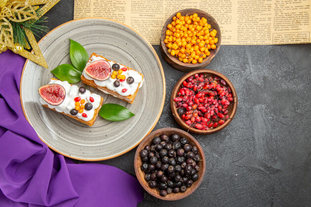 甜点在黑暗的桌子上俯瞰美味的华夫饼和新鲜水果橄榄配料菜肴