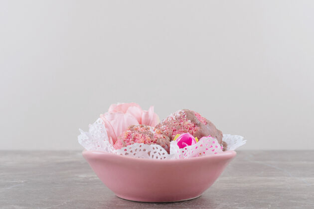 口感小蛋糕和花冠放在一个铺着桌布的碗里 放在大理石上碗花美味