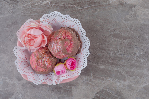 口感小蛋糕和花冠放在一个铺着桌布的碗里 放在大理石上美味花蛋糕