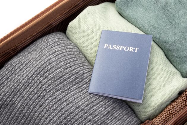护照打开的行李和折叠的衣服和护照平面图衣服旅游