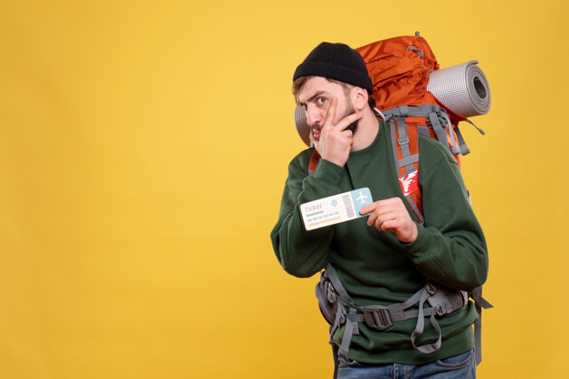 职业旅行概念与好奇的年轻人与背包和出示黄色的机票脸黑人