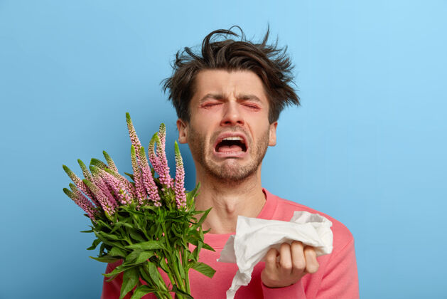 男性忧郁症中的可怜人患有过敏性疾病和鼻炎 季节性疾病 打喷嚏累了 鼻子和眼睛发红 对花过敏 手帕 感到不适疾病凌乱反应