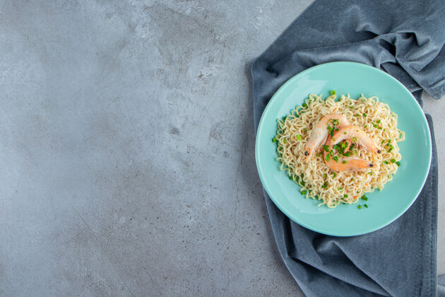 盘子面条和虾放在一块布上 放在大理石背景上布料意大利面午餐