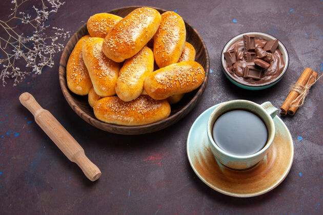 面包顶视图甜饼加上一杯茶和巧克力的深色背景糕点面团餐食品饼茶面包食物椒盐卷饼